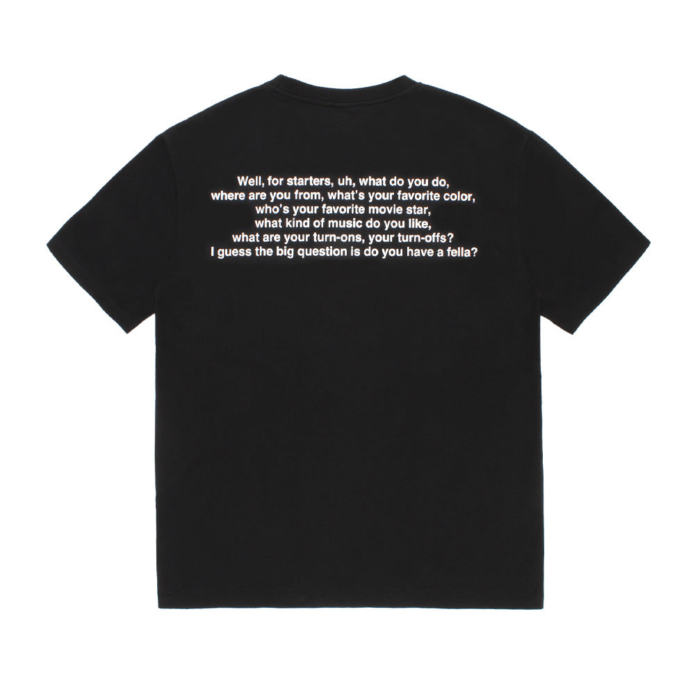 Back flat lay studio view of the black Wacko Maria x True Romance Washed Heavy Weight T-Shirt, highlighting the clean dropped shoulders, straight hem, and centered upper back white typography print featuring Clarence Worley's iconic movie dialogue quote.