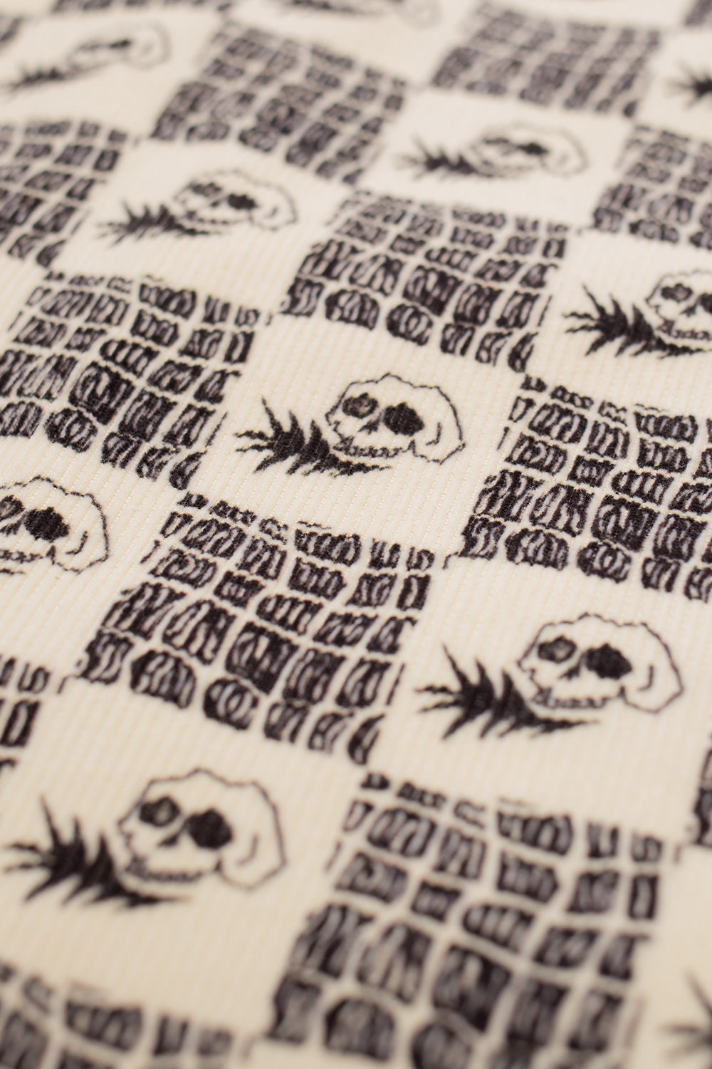 close-up of Wacko Maria Wolf’s Head shirt pattern featuring repeating skull artwork and vintage typography style graphics, rockabilly inspired Japanese streetwear design